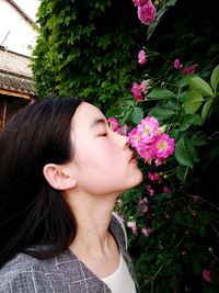 Close-up portrait of woman with pink flower