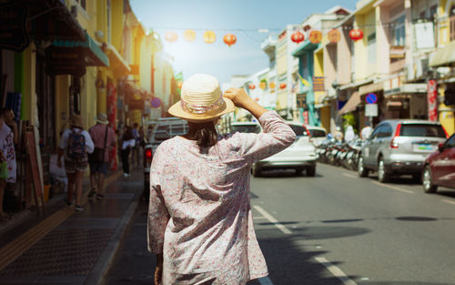 Rear view of woman walking on street in city