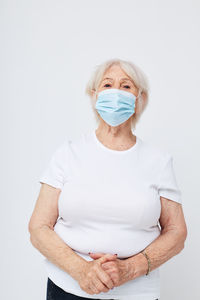 Portrait of woman wearing mask against white background