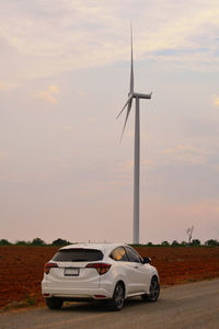 Car on field against sky during sunset