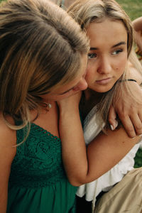Teenage girl hugging female friend looking away