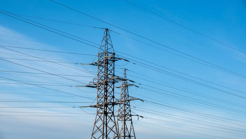 Low angle view of electricity pylon against clear sky