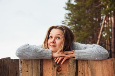 Young beautiful girl near wooden fence