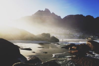 Scenic view of mountains and beach on sunny day