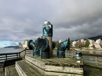 Built structure by sea against sky in city