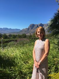 Portrait of woman standing on field against sky