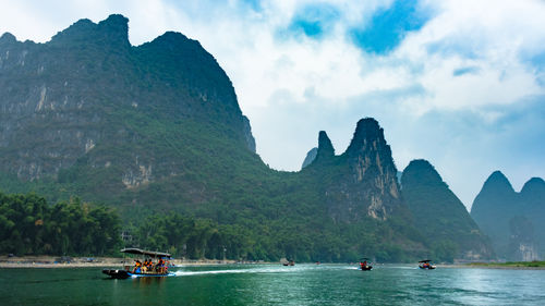 Scenic view of sea and mountains against sky