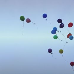 Low angle view of colorful balloons against blue sky