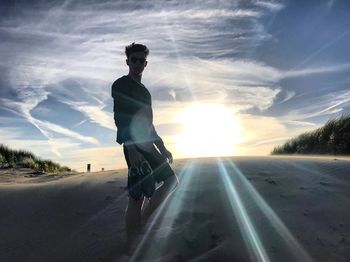 Man standing at beach against sky