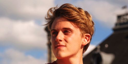 Close-up portrait of teenage girl against sky