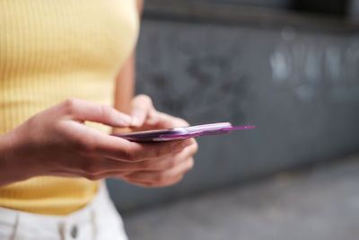 Midsection of woman using mobile phone