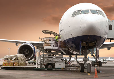 Airplane on airport runway against sky