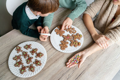 High angle view of mother with kids preparing cookies at home