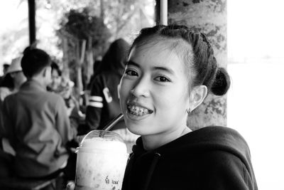 Portrait of smiling boy drinking glass at restaurant