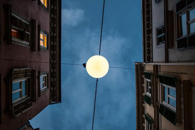 Low angle view of illuminated street light against sky