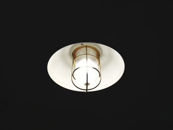 Low angle view of illuminated light bulb against black background