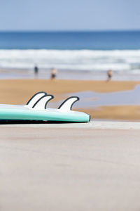 The blue of the sea with a surfboard in the foreground on the sandy beach. relaxing outdoor