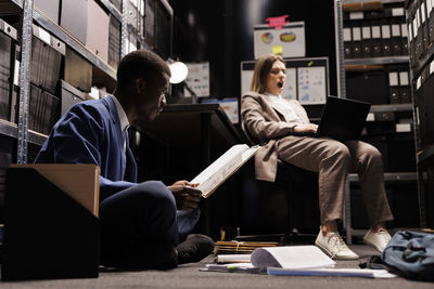 Rear view of woman using laptop at office