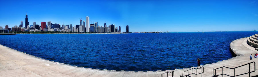 Sea and buildings against blue sky