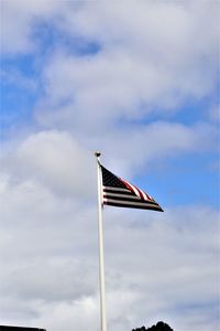 Low angle view of american flag against cloudy sky