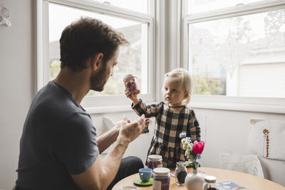 Father and daughter having tea party in playroom