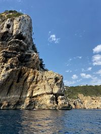 Rock formations by sea against sky