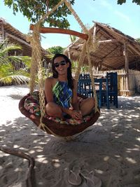 Portrait of smiling young woman sitting on sand