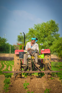 Man standing on field against trees