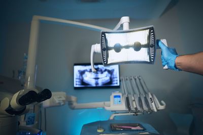 Low angle view of dentist adjusting light in examination room