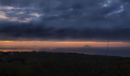 Silhouette of landscape against cloudy sky