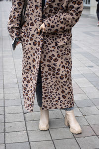 Low section of woman standing on footpath