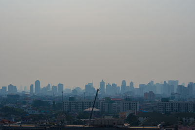 Buildings in city against clear sky