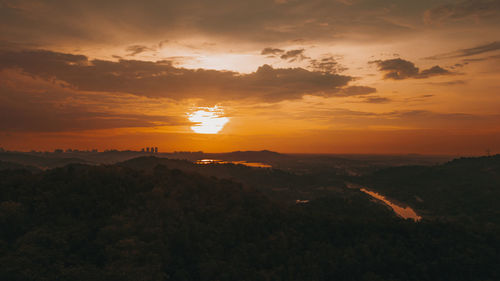 Amazing aerial view on the orange sky, sunset sun and clouds.