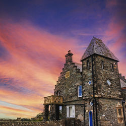 Low angle view of old building against sky during sunset