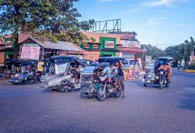 People on road against sky in city