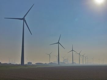 Low angle view of wind turbine against blue sky