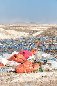 Garbage bin on land against sky