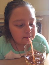 Close-up of girl drinking ice tea at home