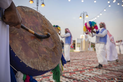 Close-up of men playing with umbrella