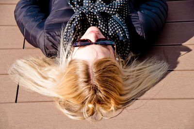 High angle view of woman lying on floorboard