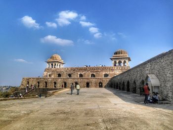 Tourists at historical building against sky