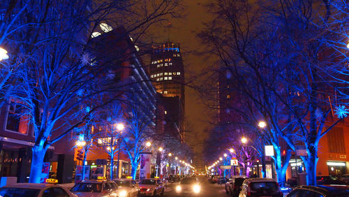 Illuminated city against sky at night