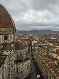 Aerial view of city against cloudy sky