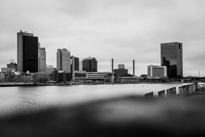 Buildings in city against sky off the riverfront 