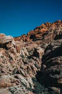 Low angle view of rock formation against clear blue sky