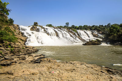 Scenic view of waterfall against clear sky