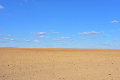 Scenic view of desert against blue sky