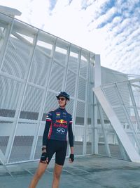 Portrait of young woman standing against built structure