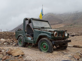 Old vintage car on field against sky - 4x4