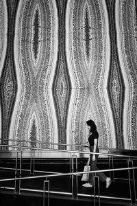 Side view of woman standing against building